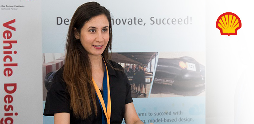 A college-aged Altair-sponsored team member standing in front of a Shell Eco-marathon banner at an award ceremony.